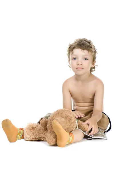 Мальчик играет в игрушечного медведя на белом — стоковое фото