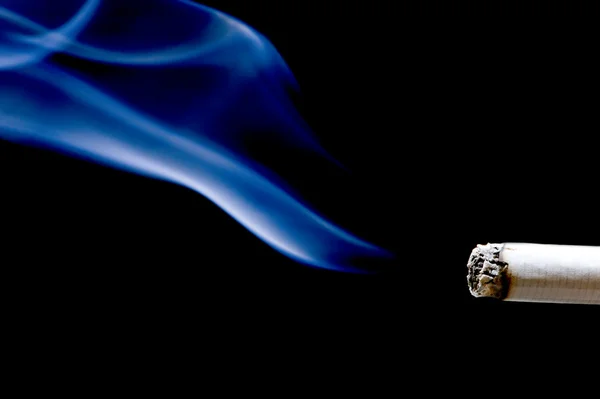 Сигарета с дымом на черном фоне — стоковое фото
