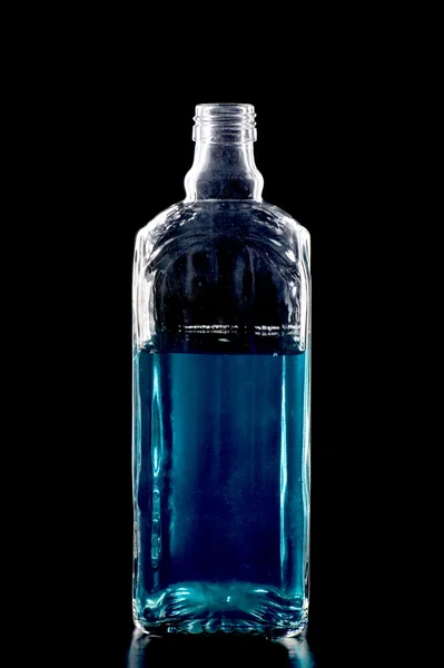 Barevná láhev s kapalinou na černém pozadí — Stock fotografie