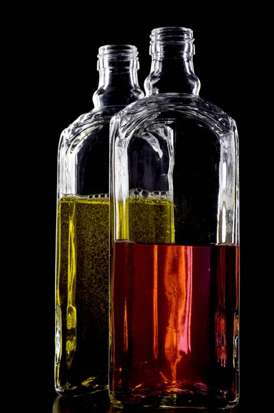 Colorido duas garrafas em preto — Fotografia de Stock