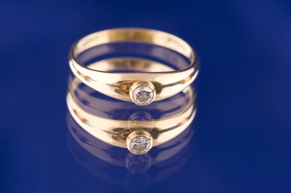 Golden ring with stone on blue — Stock Photo, Image