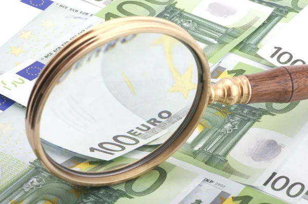 Magnifying glass with money — Stock Photo, Image