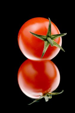 Ripe tomato on black background clipart