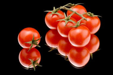 Ripe tomato on black close up clipart