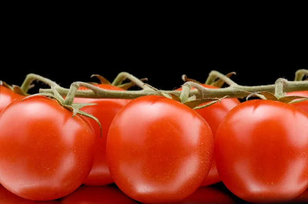 Спелые помидоры на черном макросе — стоковое фото