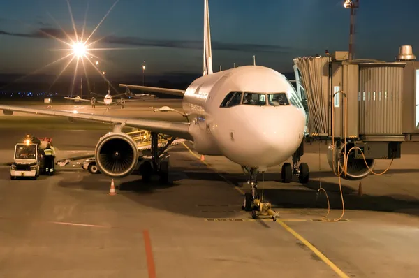 Vliegtuig op de luchthaven geparkeerd in de nacht — Stockfoto