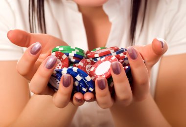 Girls hands holding a bunch of poker chips clipart