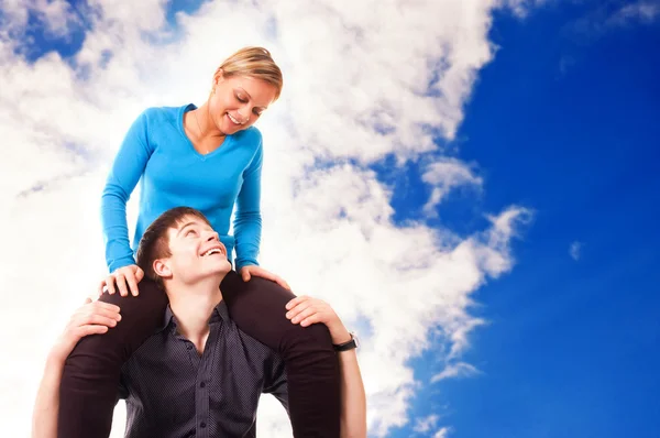 Giovane coppia si sta divertendo (sfondo cielo blu ) — Foto Stock