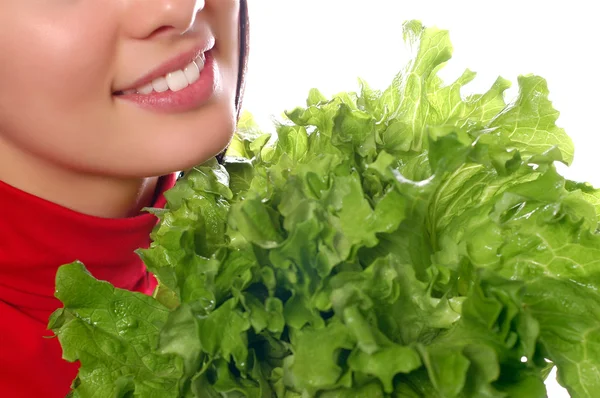 Girl is holding a leaf of salad — Stock Photo, Image
