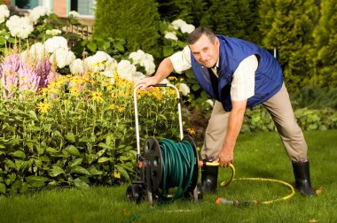 Man crimping hose in the garden clipart