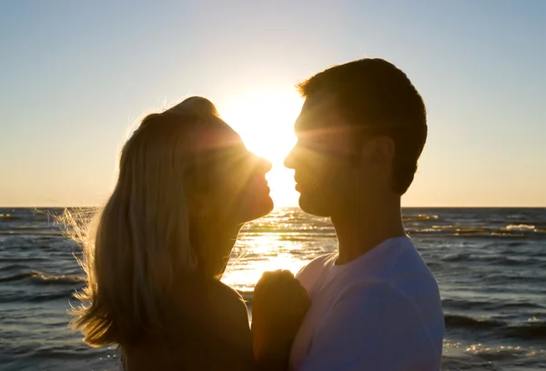 Casal abraço, curtindo o pôr do sol de verão . — Fotografia de Stock