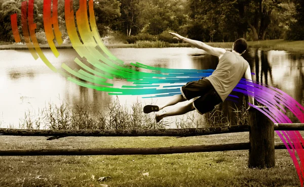 Man springen over het hek op de regenboog — Stockfoto