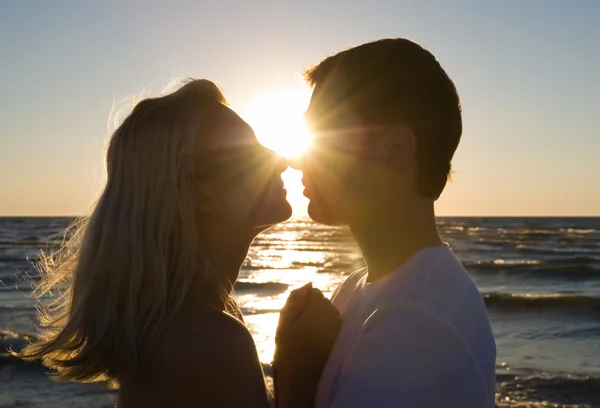 Casal abraço, curtindo o pôr do sol de verão . — Fotografia de Stock