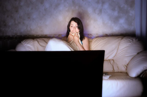 Σημαδεμένος κορίτσι βλέποντας τηλεόραση σε έναν καναπέ — Φωτογραφία Αρχείου