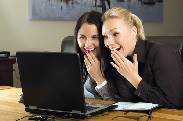 Две девушки с ноутбуком в офисе — стоковое фото