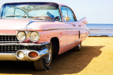 Classic pink car at beach clipart