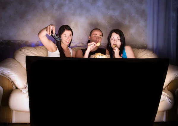 Tři přátelé sledují televizi — Stock fotografie