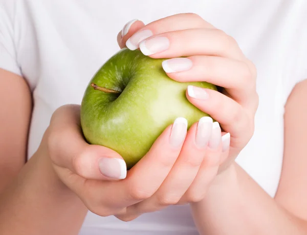 Zelené jablko v rukou ženy — Stock fotografie