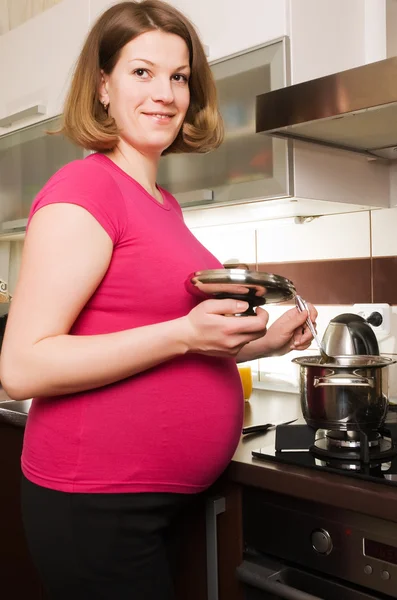 Молода вагітна жінка на кухні — стокове фото