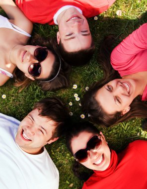 Group of friends lying on grass clipart