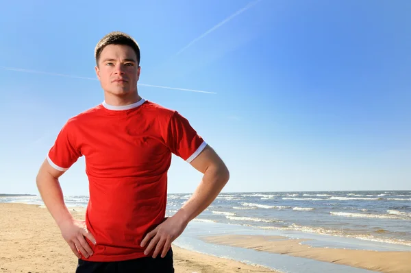 Young man standing at beach — Stock Photo, Image