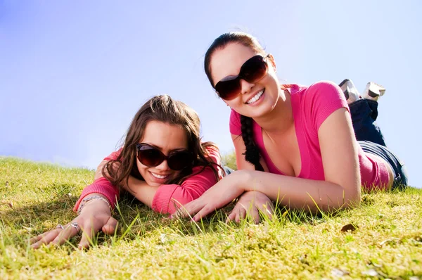 Två flickor avkopplande i en park — Stockfoto