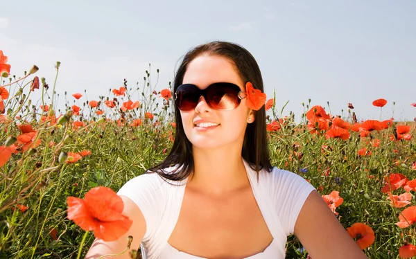 Jonge mooie vrouw in poppy bloemen — Stockfoto