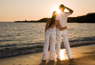 Couple hugging, enjoying summer sunset. clipart