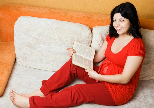 Těhotná žena sedící na gauči — Stock fotografie
