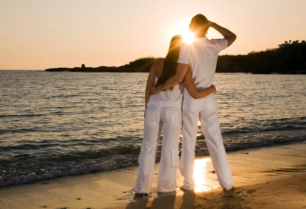 Paar umarmt sich, genießt den sommerlichen Sonnenuntergang. — Stockfoto