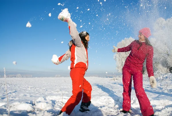 Две девушки играют со снегом — стоковое фото