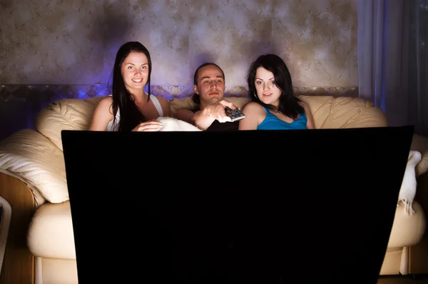 Três amigos estão assistindo TV — Fotografia de Stock