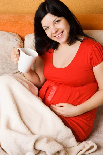 Gravid kvinna sitter i soffan — Stockfoto