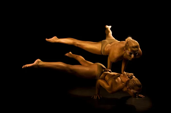Due acrobatica ragazza tonica in oro — Foto Stock