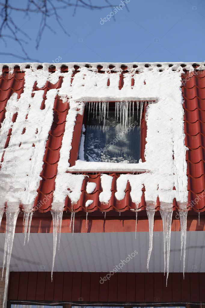 Icicles on building roof at winter day