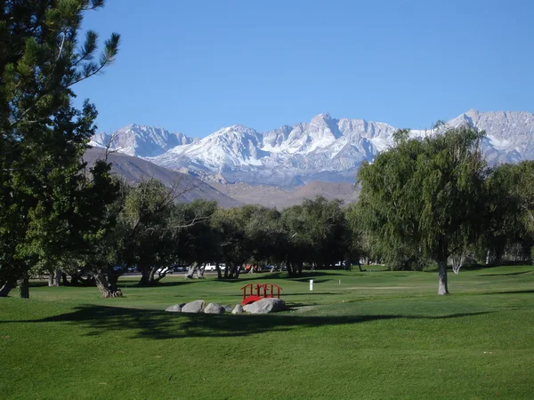 Golfbaan met bergen op de achtergrond — Stockfoto