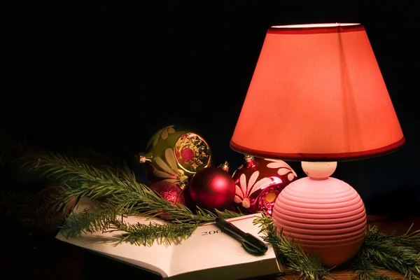 Desk lamp and christmas-tree decorations — Stock Photo, Image