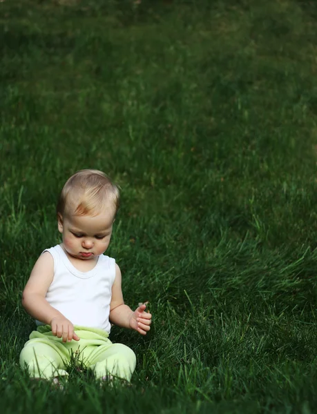 Liitle çocuk bir çimenlerin üzerinde — Stok fotoğraf