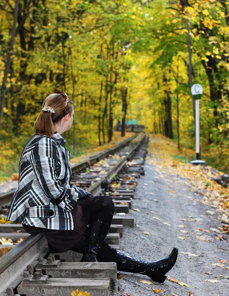 Les jeunes femmes s'assoient sur un rail — Photo