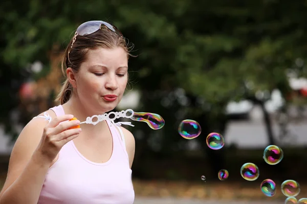 Mujer Yung sopla burbujas — Foto de Stock