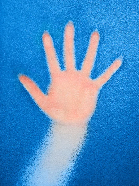 Weibliche Handfläche hinter nassem Glas in blauer Tonne — Stockfoto