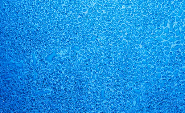 Vidro molhado com gotas de água em tom azul — Fotografia de Stock