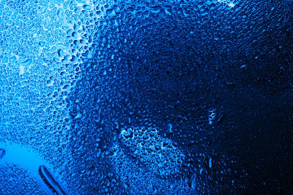 用水淋湿的玻璃滴在蓝色色调 — 图库照片
