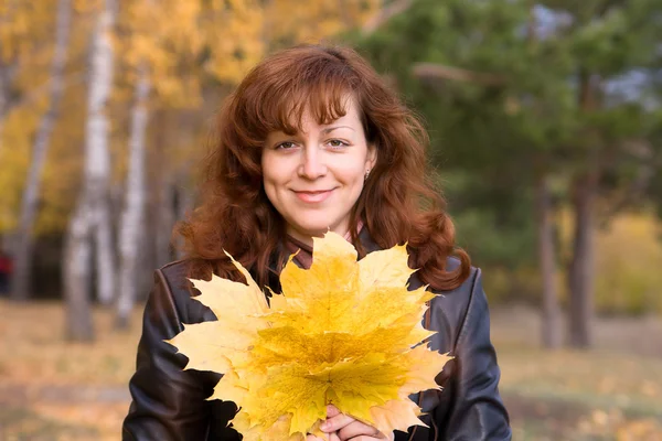 Lachende vrouw met maple leafs — Stockfoto