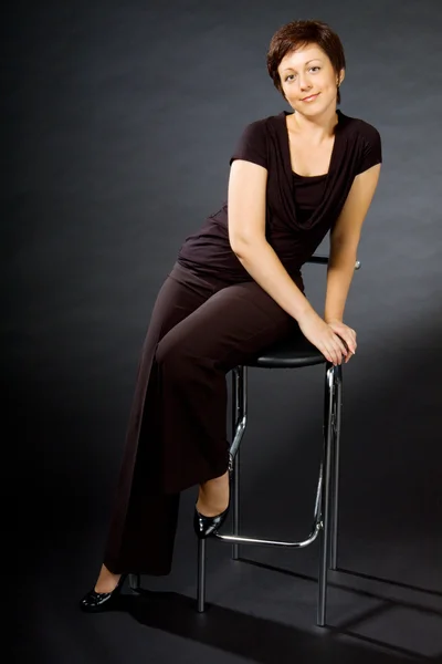 Jonge vrouw zittend op stoel — Stockfoto