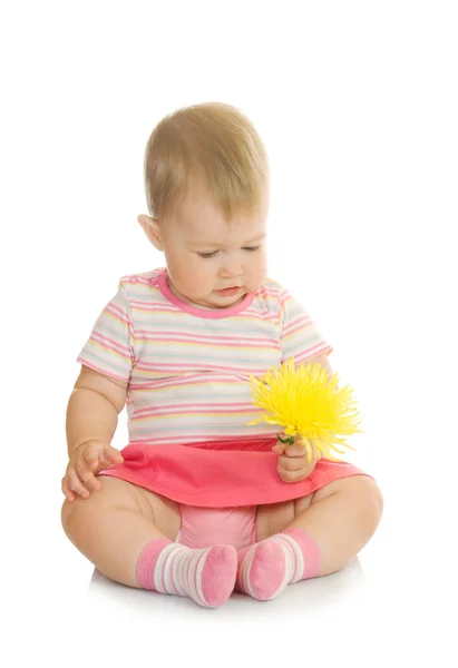 Sedí malé dítě s žlutým květem — Stock fotografie