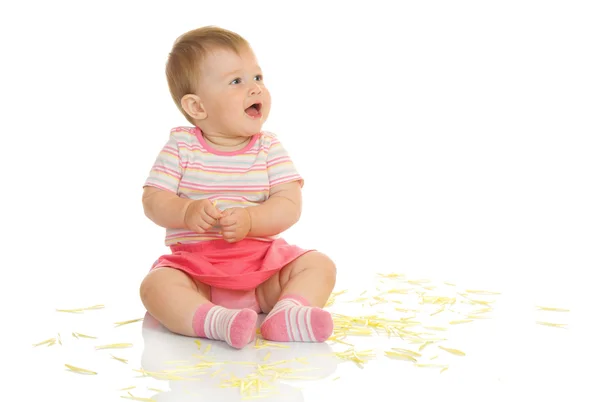 Sentado bebé pequeño con pétalos amarillos — Foto de Stock