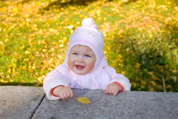 Smiling baby with yellow leaf — Stock Photo, Image