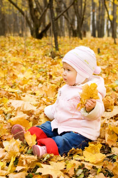 Sentado bebê pequeno brincando com m amarelo — Fotografia de Stock