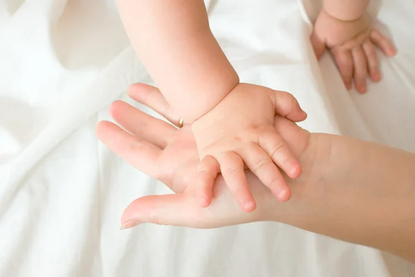 Hände eines kleinen Babys und seiner Mutter — Stockfoto